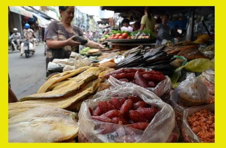 A steaming bowl of pho in a Vietnamese street food stall