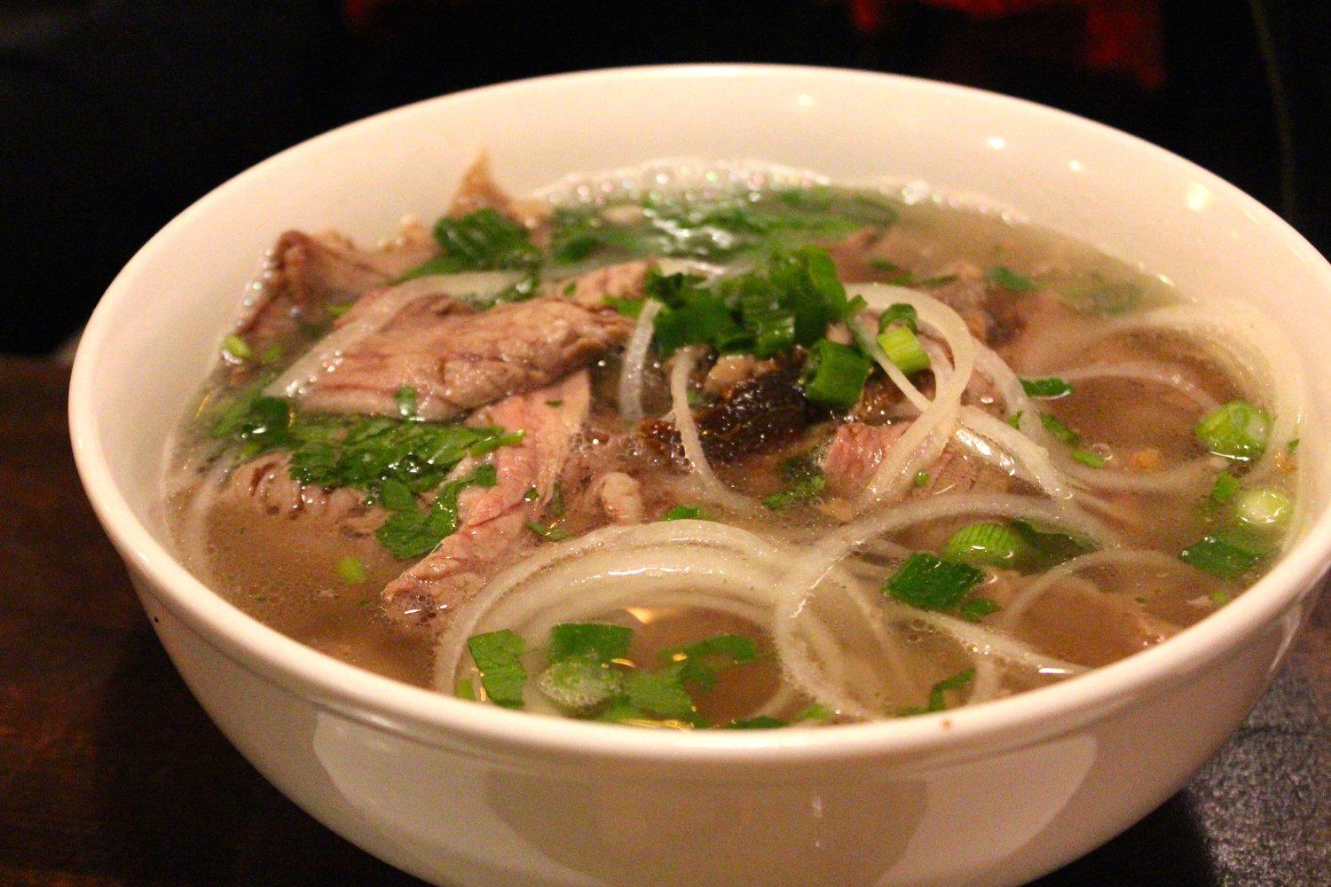 A steaming bowl of Pho, a popular Vietnamese street food dish